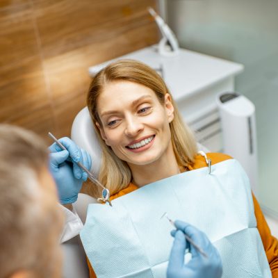 Beautiful woman as a patient during a teeth inspection with a senior experienced dentist at the clinic